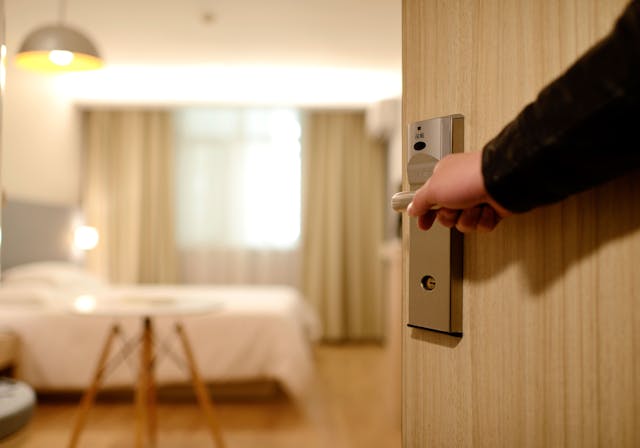 person opening a hotel room door