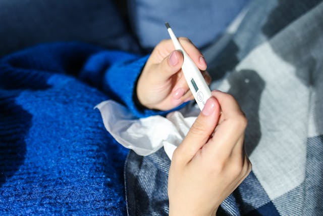 Person holding a thermometer 